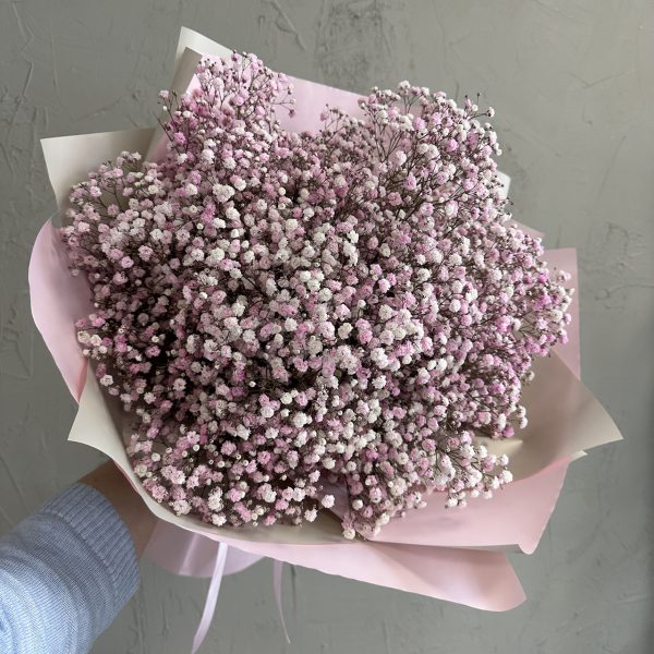 Close-up of a pink gypsophila bouquet wrapped in soft pink and cream paper