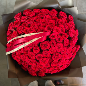 Large bouquet of vibrant red roses wrapped in black paper with red and cream KS Bloomery ribbon.