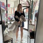 Woman holding a grey teddy bear inside KS Bloomery shop in Northampton.