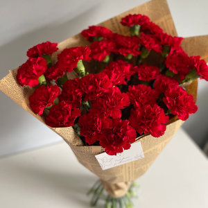 Vibrant red carnation bouquet in vintage-style newspaper wrap with KS Bloomery label.