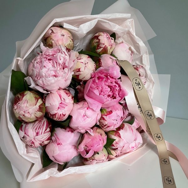 Bouquet of pink and blush peonies wrapped in white paper with KS Bloomery ribbon