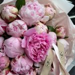 Close-up of a bouquet of pink peonies with KS Bloomery branded ribbon