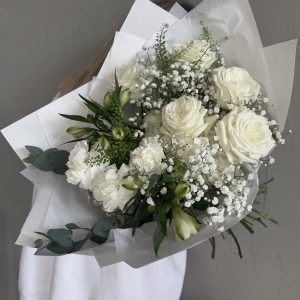 Elegant white bouquet with roses, carnations, alstroemeria, baby’s breath and eucalyptus foliage.