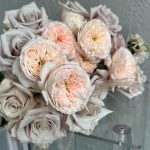 Close-up of a romantic bouquet with soft blush garden roses and pale taupe roses, accented with delicate wisps of dried grass.